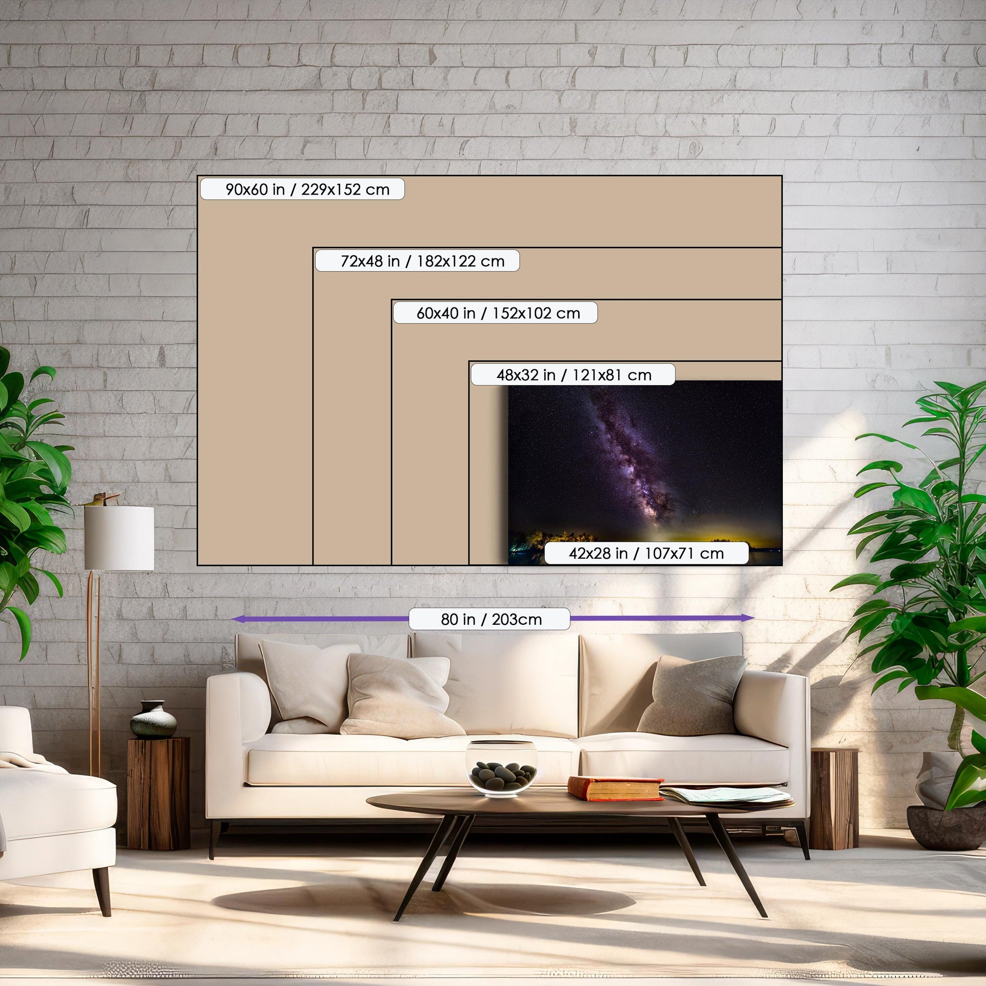 A vivid Milky Way core glows in a vertical sweep across a dark, starry night sky. The stars and galactic dust create a textured ribbon of light. Below, a calm lake mirrors faint reflections of the stars, with a rocky shoreline in the foreground and a glowing island of trees lit in the distance.